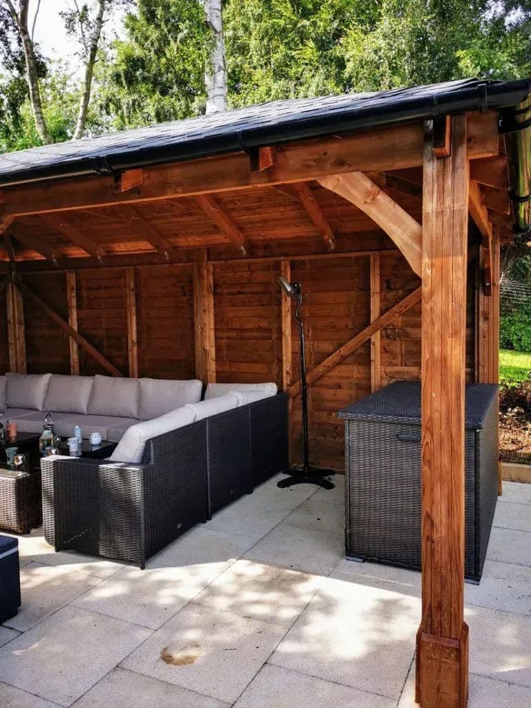 Inside the timber gazebo, with seating on the paved floor and the frame open to the garden
