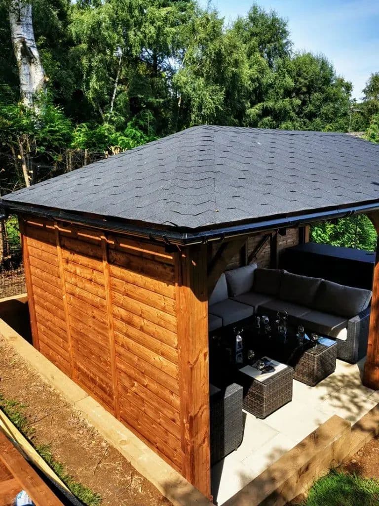 The finished gazebo with its shingled roof, seen from above the garden