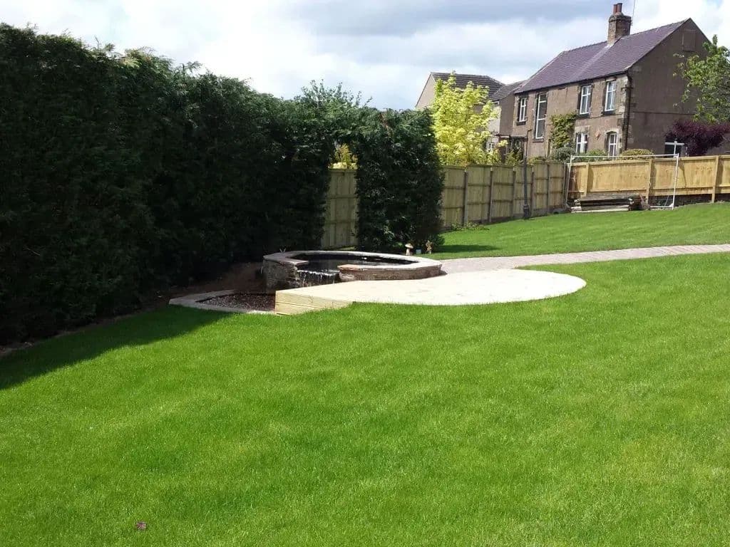 The levelled lawn with the new paved circle and a path running along the fence