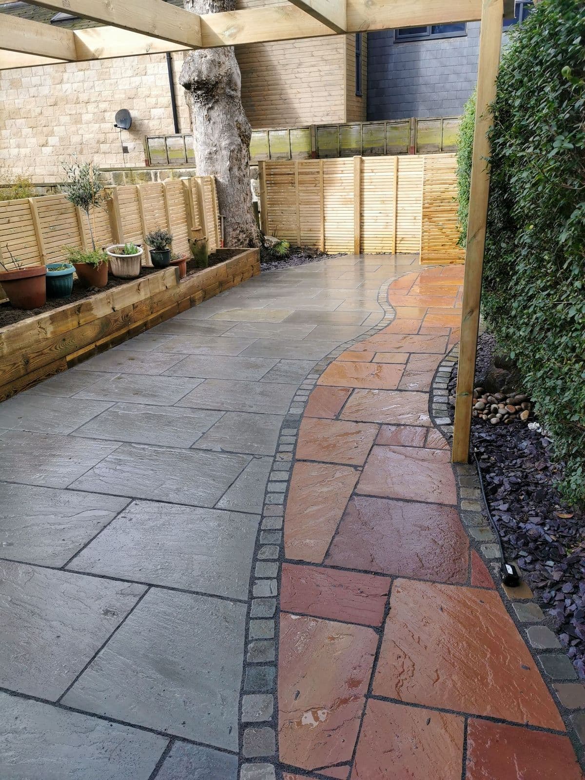 The Modak path, edged in tumbled setts, curving through the Kandla grey patio