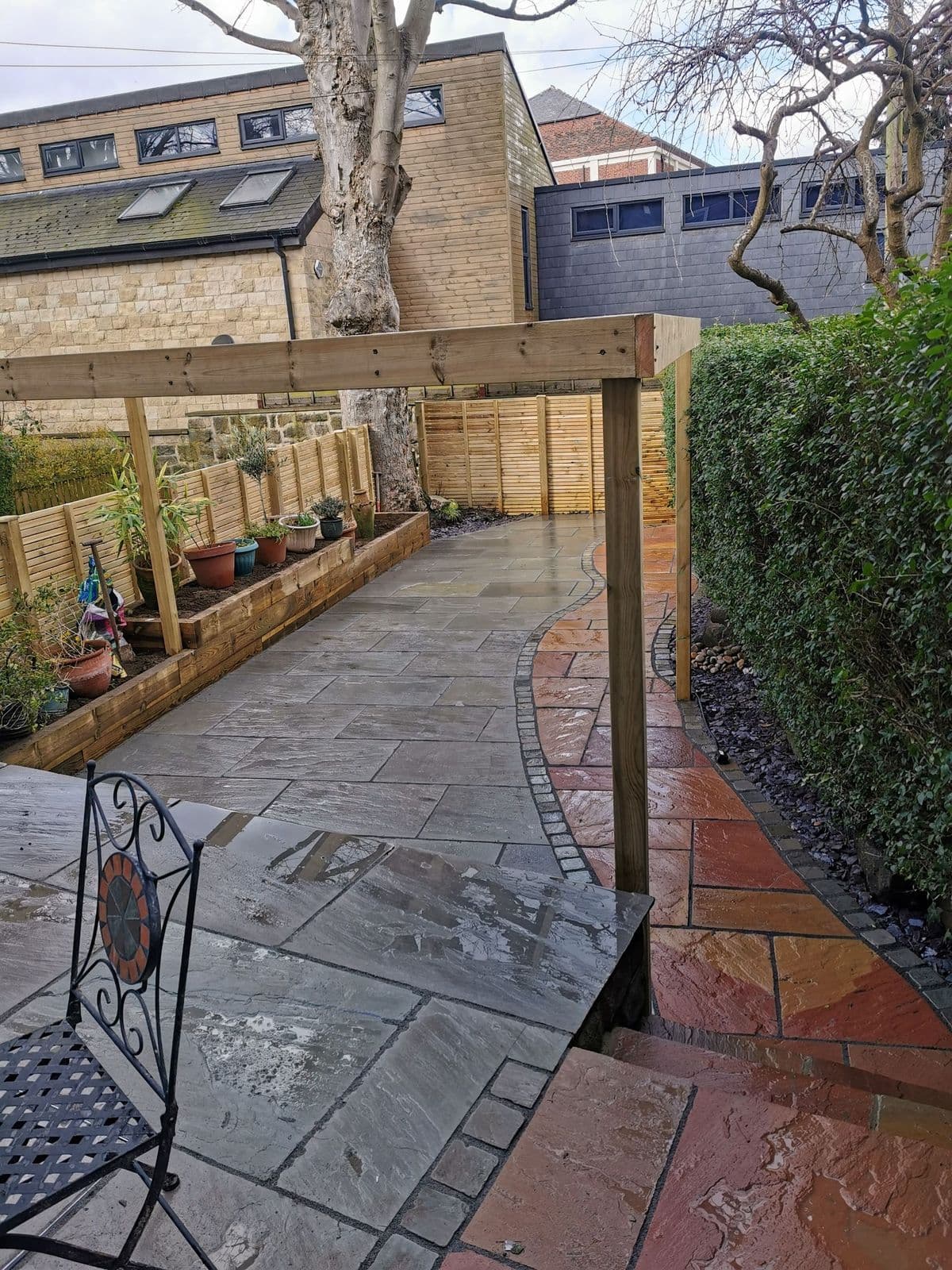 The pergola posts standing over the patio with the Modak path running past them
