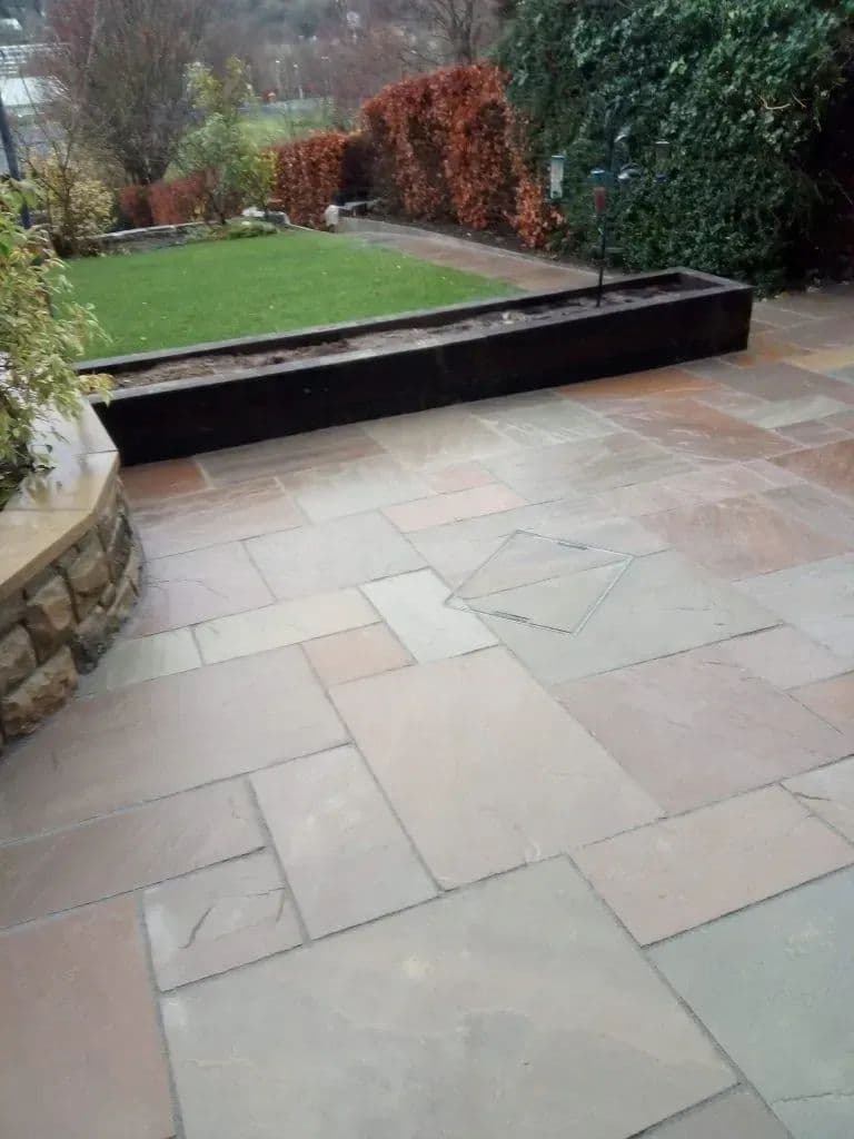 The extended patio at the nursery, with stone-faced raised beds along the edge of the lawn