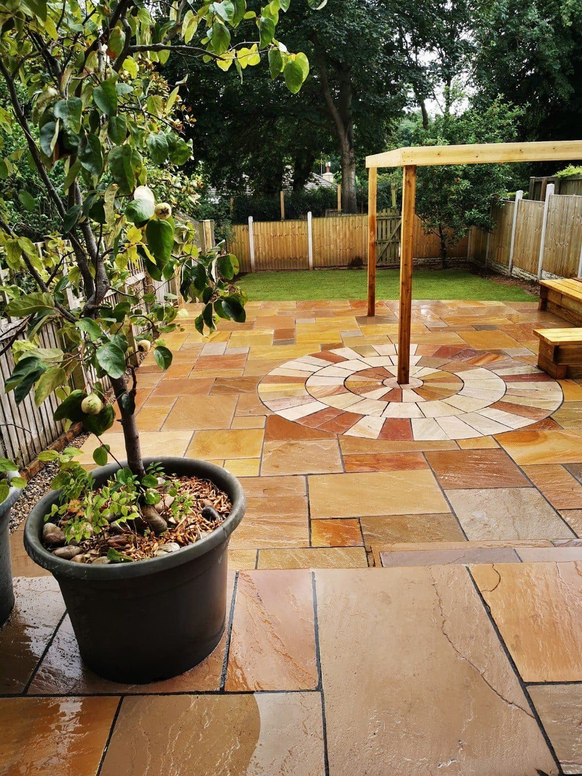 Sandstone patio with a stone circle around a pergola post