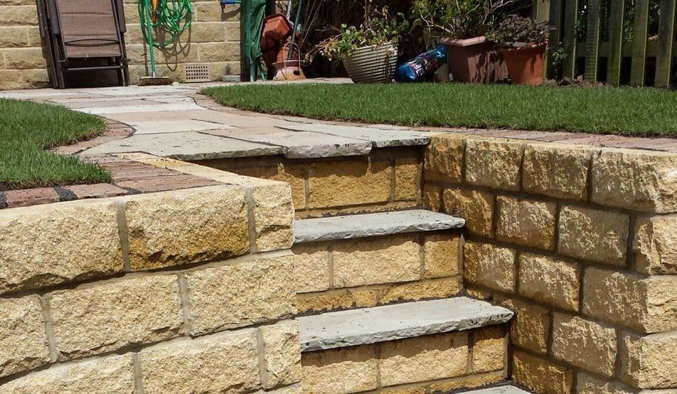 Sandstone retaining walls and steps between two lawns